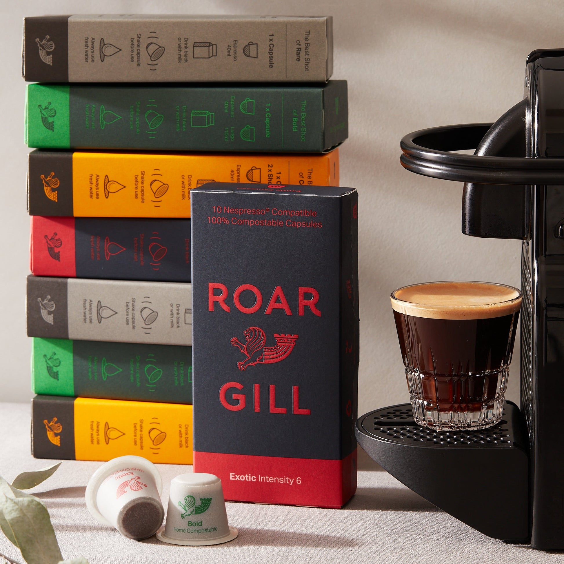 Roar Gill espresso perched on nespresso machine., next to compostable pod boxes.